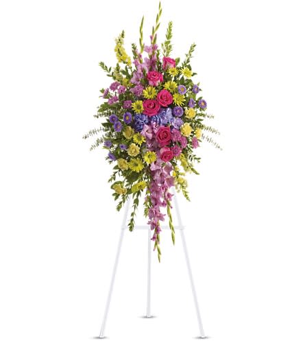 Tall standing spray of pink, purple, and yellow flowers on an easel
