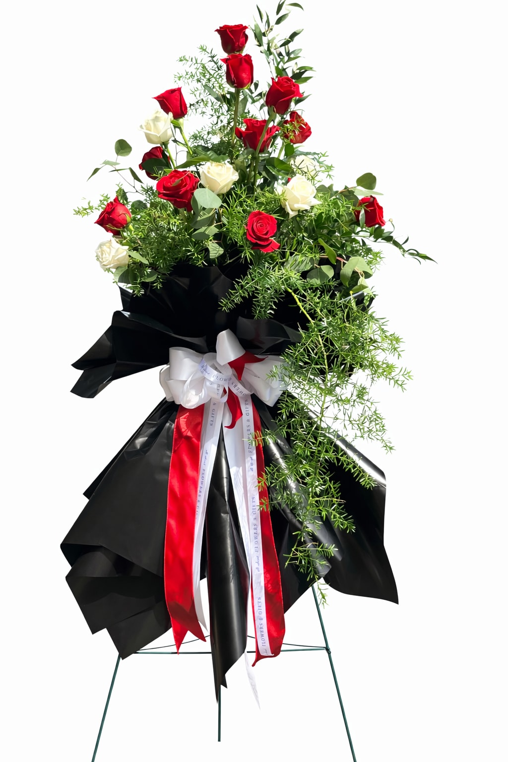 Tall standing arrangement of red and white roses with black wrap and ribbons