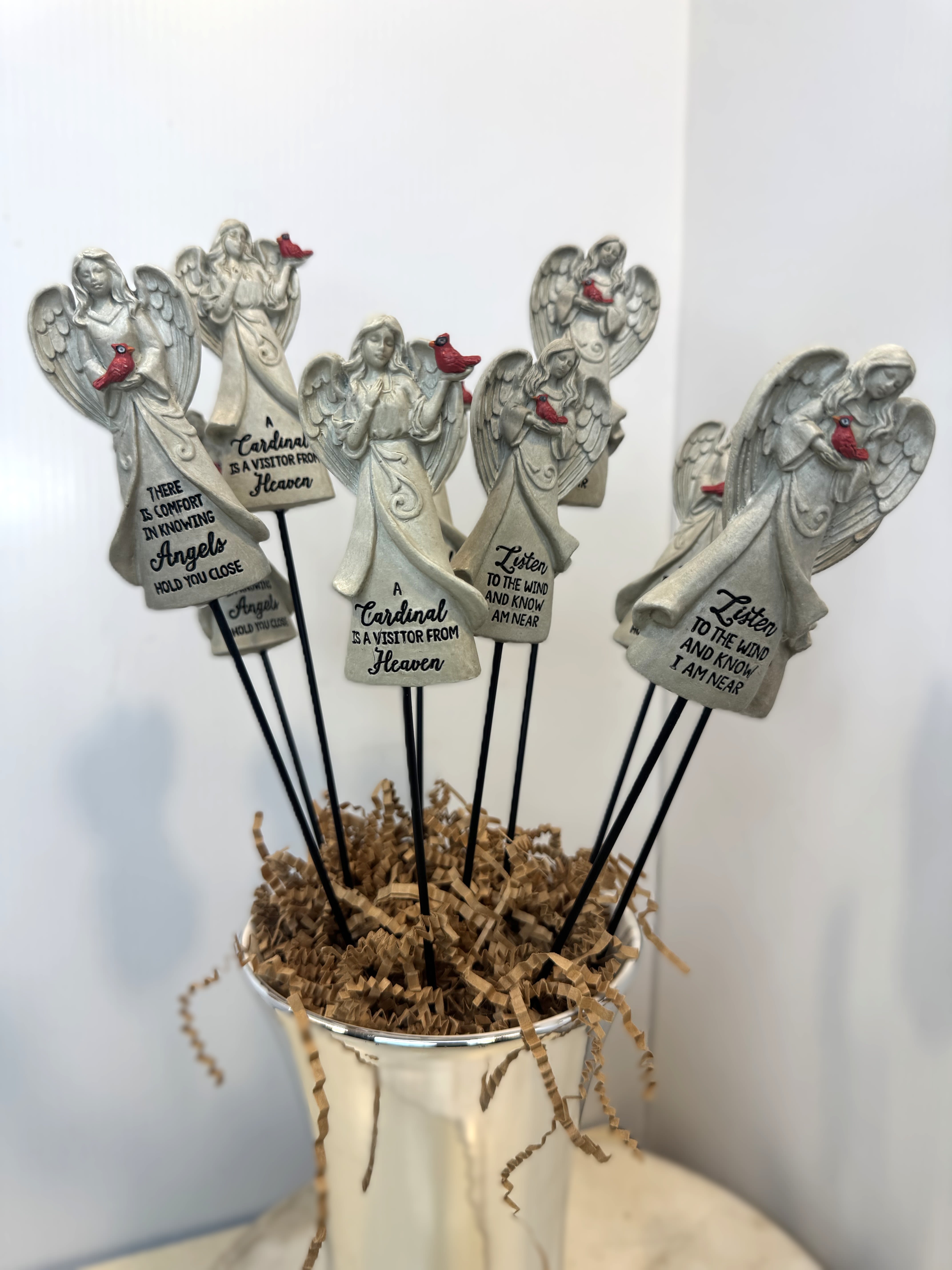 Angel figurines with cardinal accents in a white container