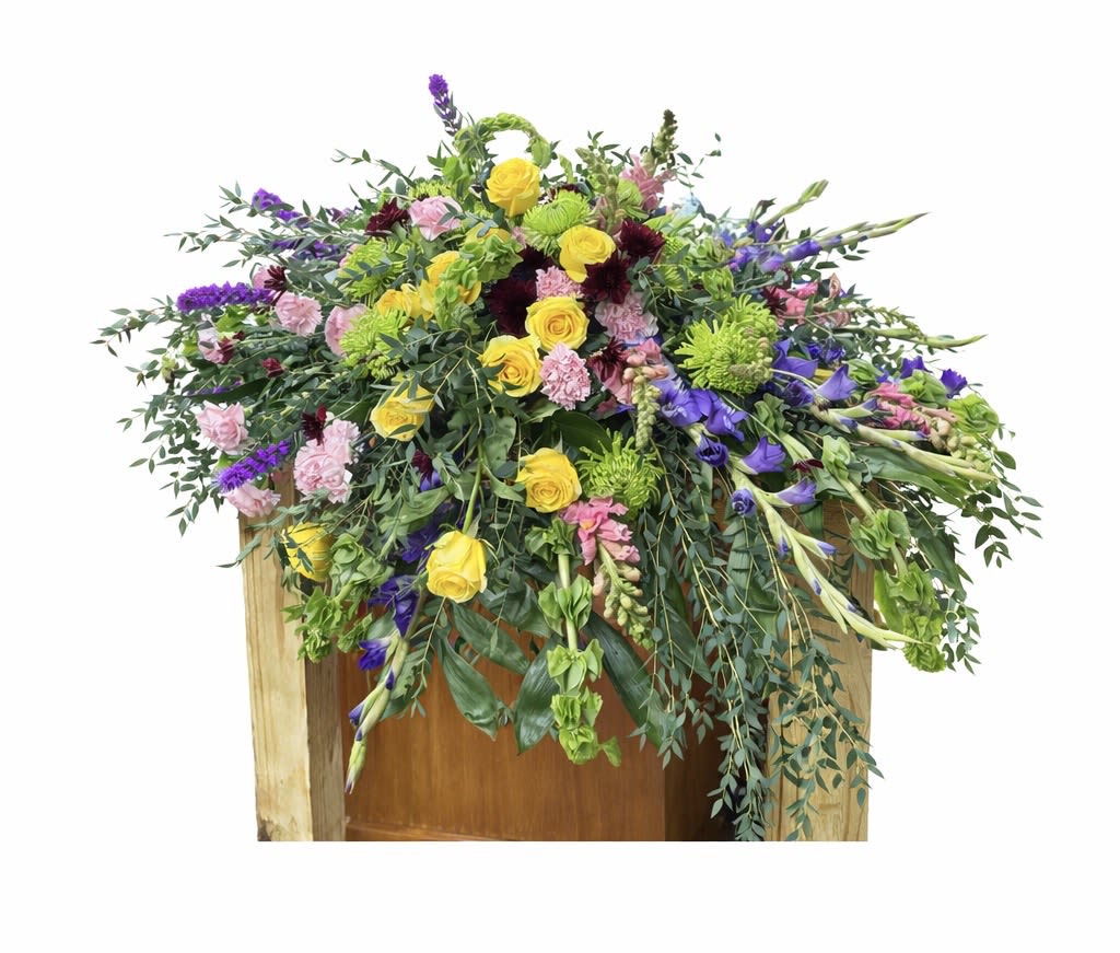 Large mixed floral arrangement with yellow roses, purple blooms, and pink flowers