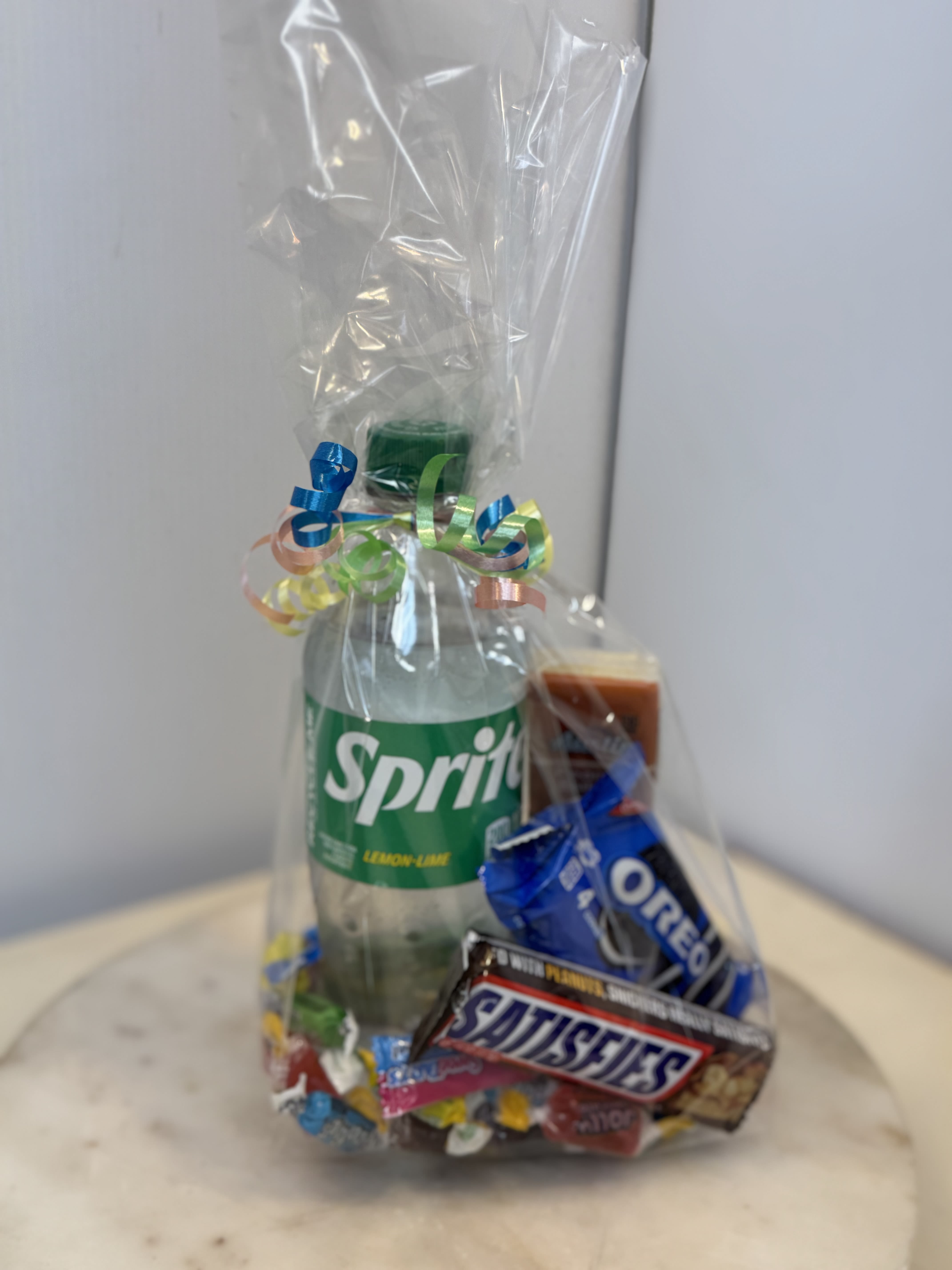 Gift bag with a Sprite bottle and assorted candy bars wrapped in clear cellophane