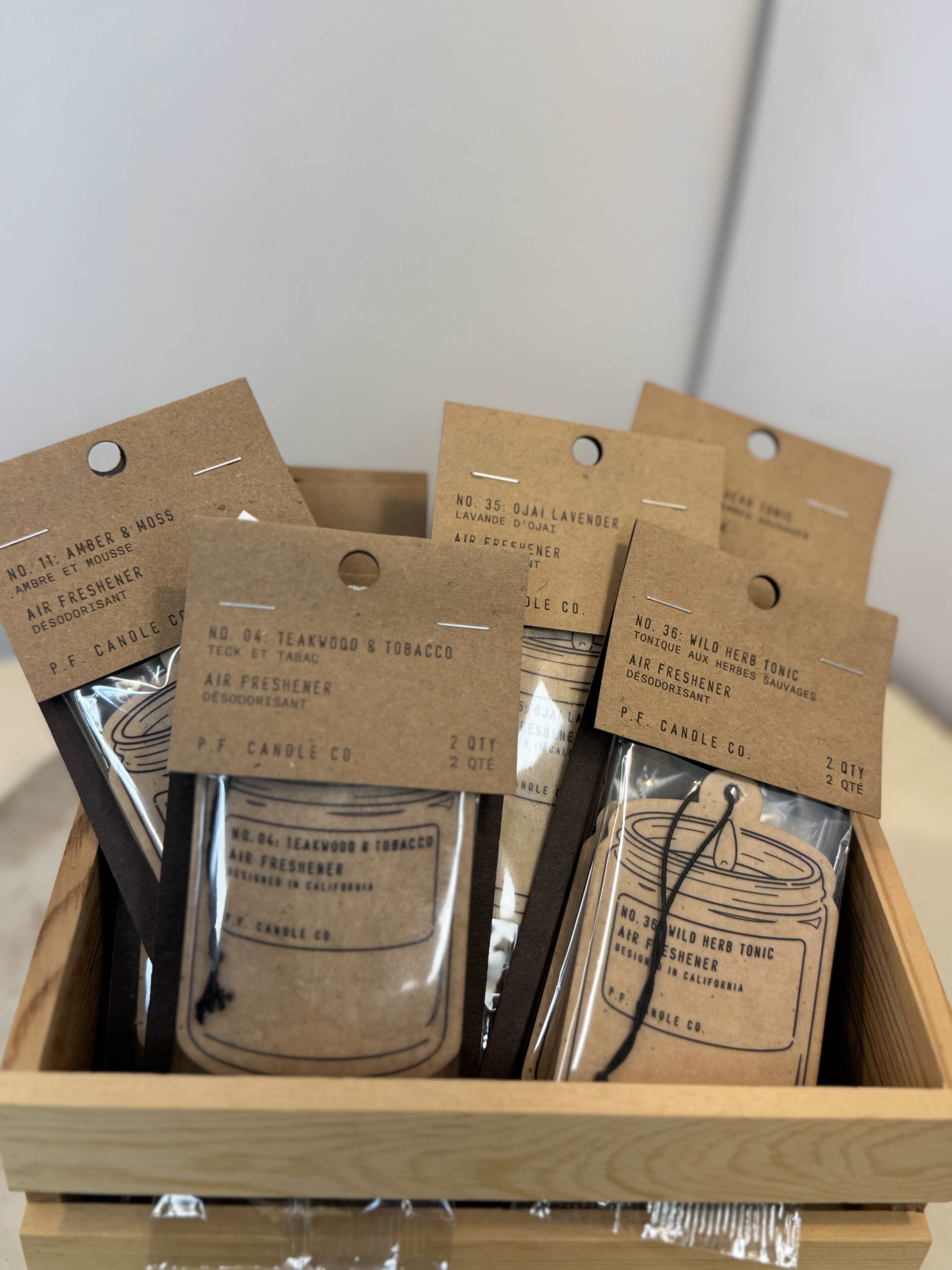 Assorted air freshener packets in a wooden tray