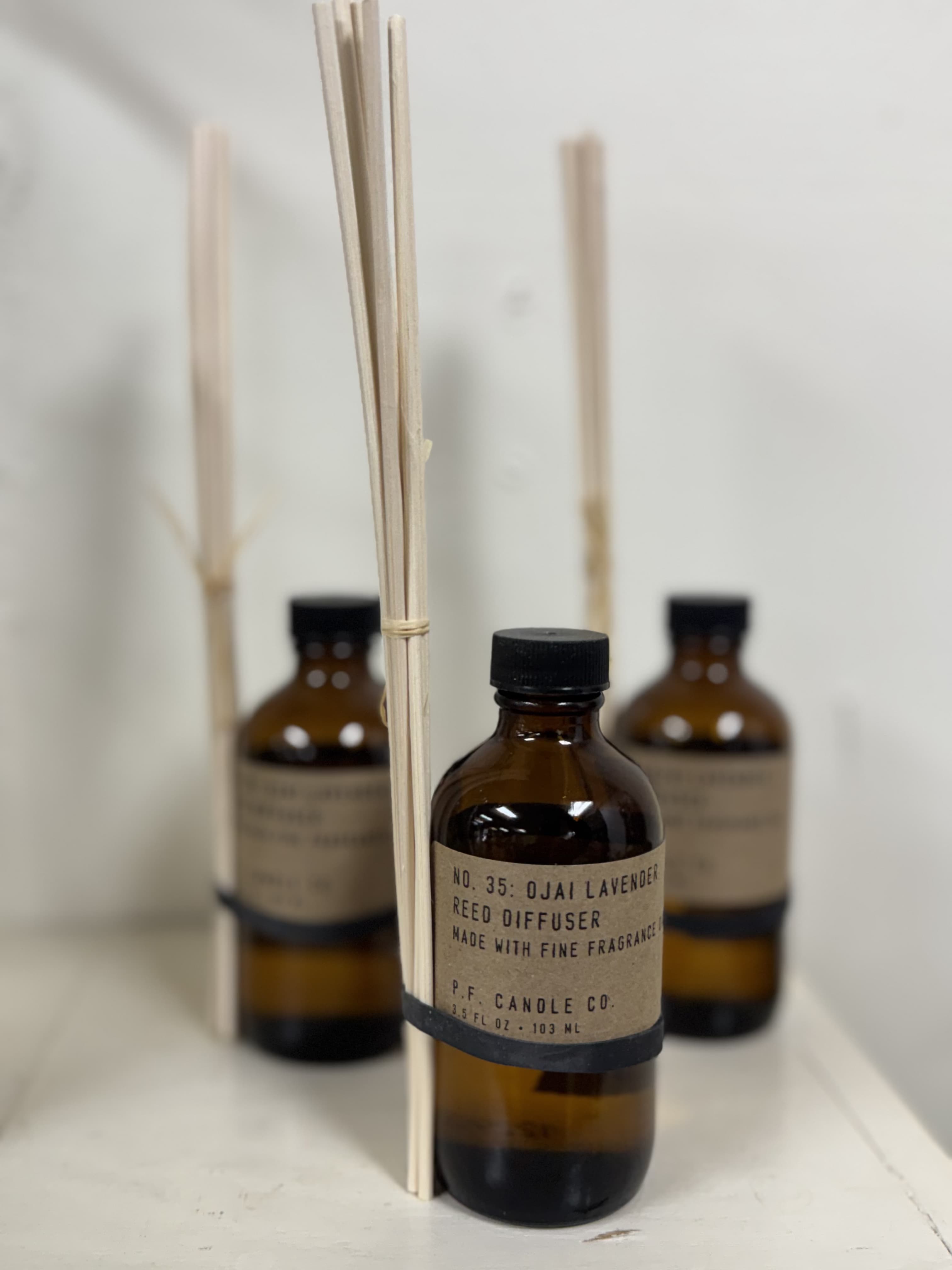 Amber reed diffuser bottles with black caps and reed sticks
