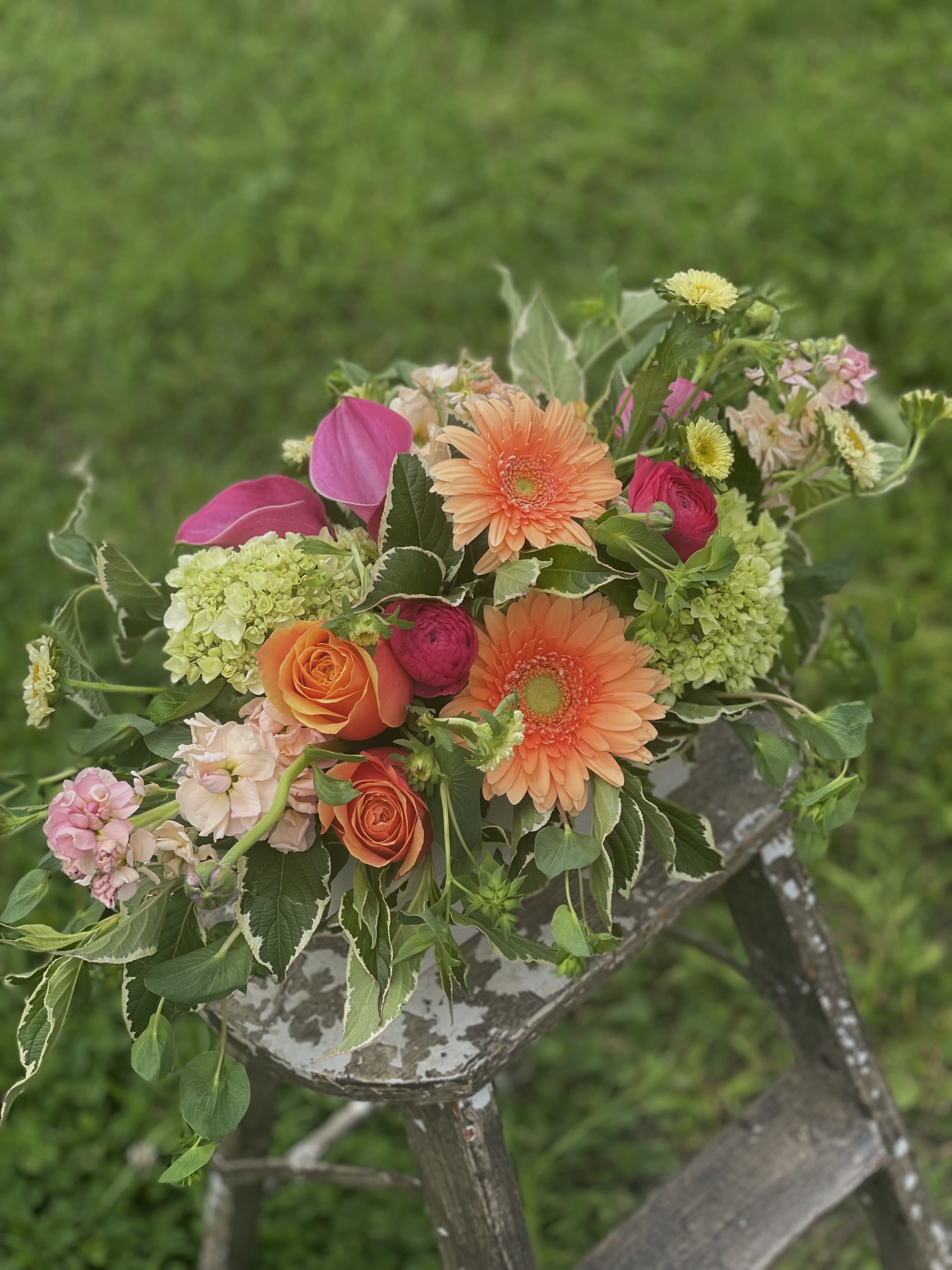Mixed bouquet with orange gerbera daisies, roses, and pink blooms