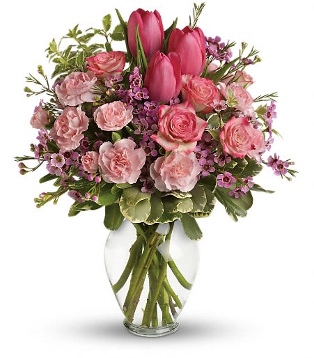 Pink tulips and roses arranged in a clear glass vase