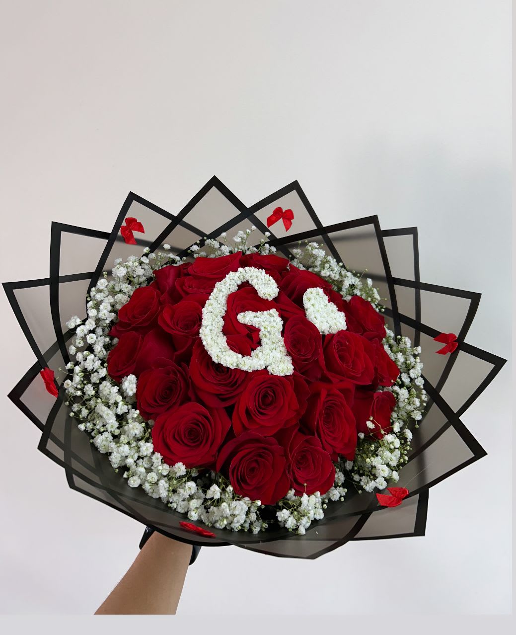 Bouquet of red roses with white baby's breath and a floral letter G