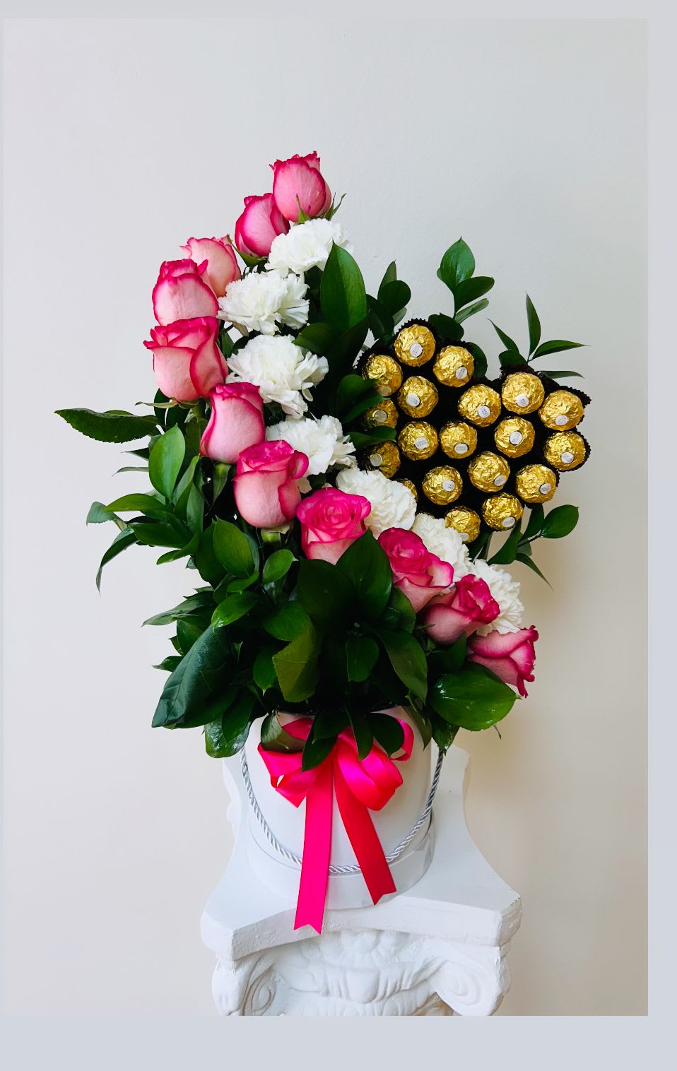 Pink roses and white carnations in a white hatbox with gold chocolates