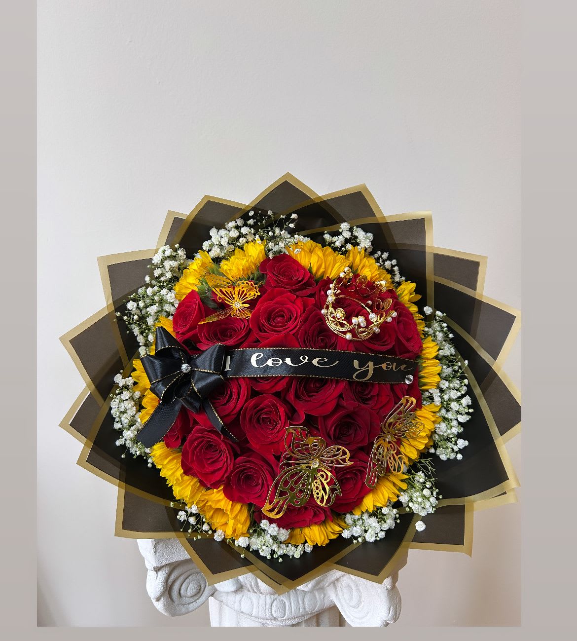 Bouquet of red roses and yellow sunflowers with a black ribbon