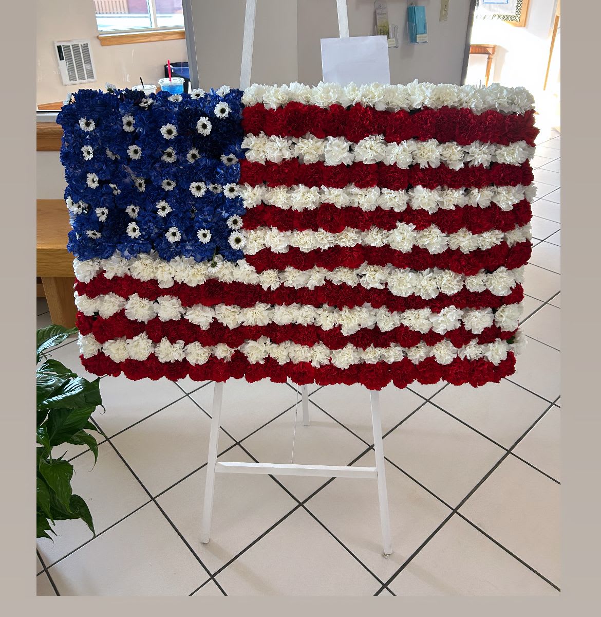 Floral American flag display on a white easel