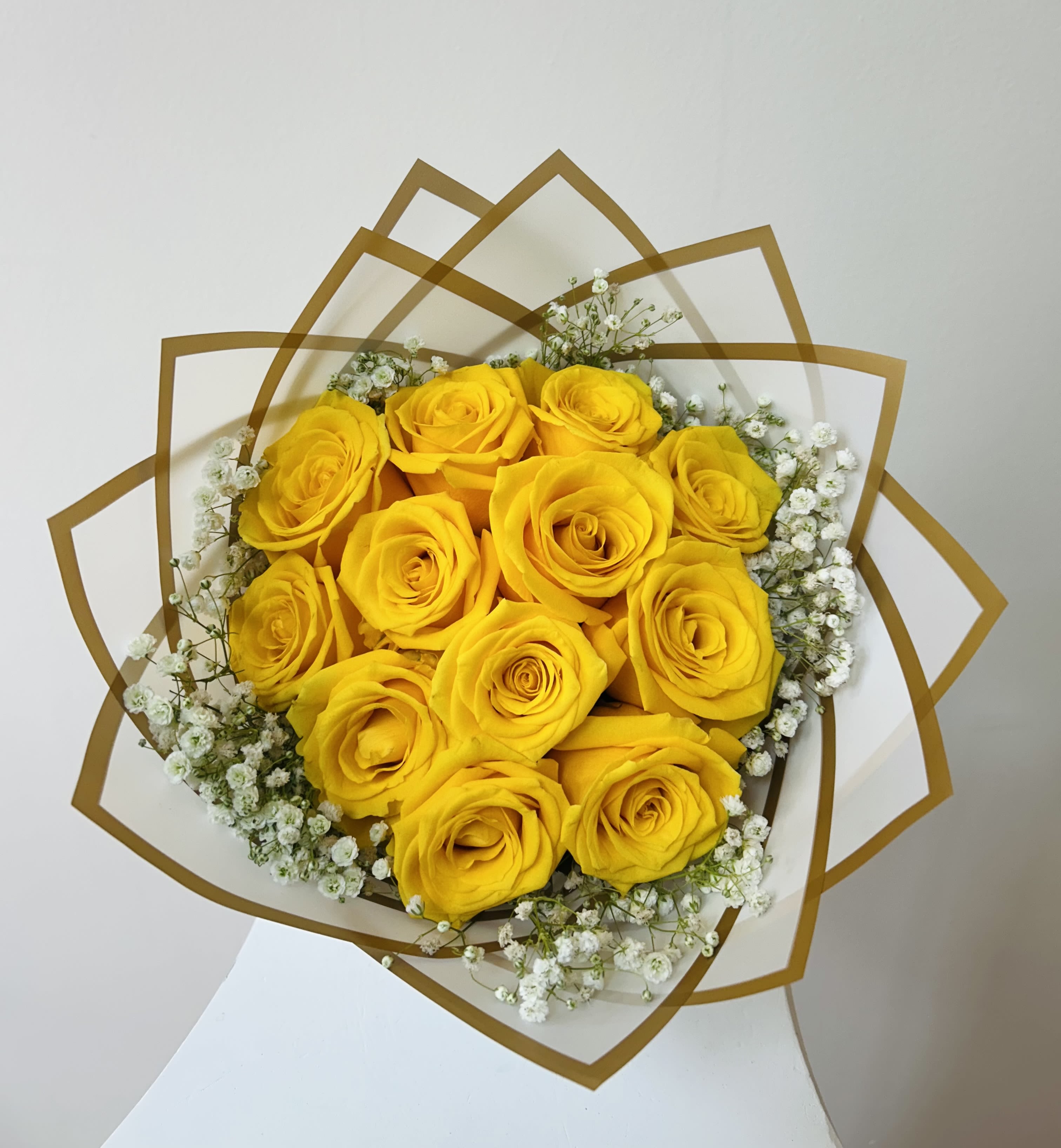 Bouquet of yellow roses with white baby's breath in decorative wrap