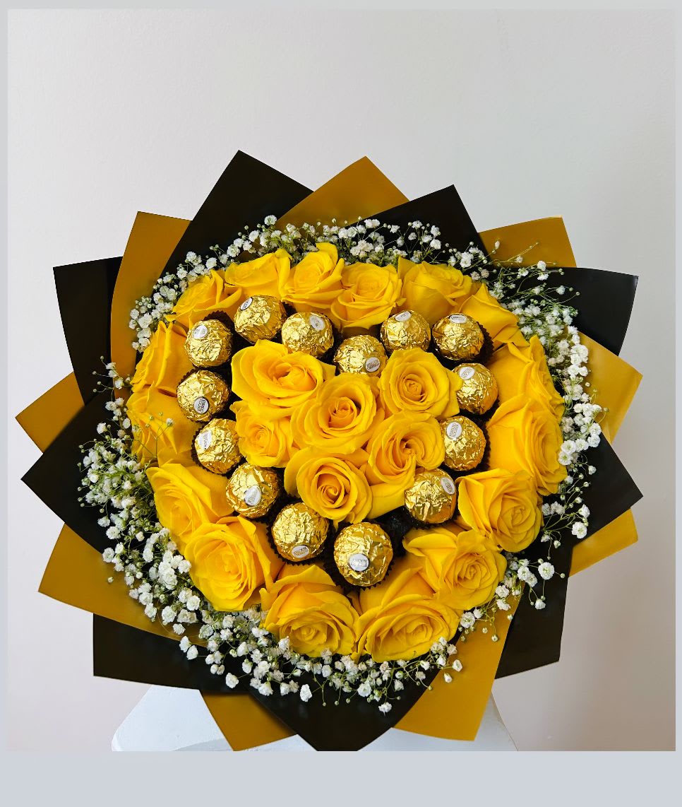 Yellow roses with gold-wrapped chocolates in a black and gold bouquet