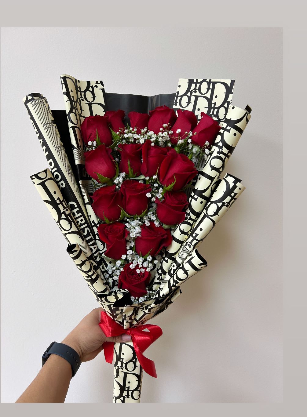 Bouquet of red roses wrapped in patterned paper with a red ribbon