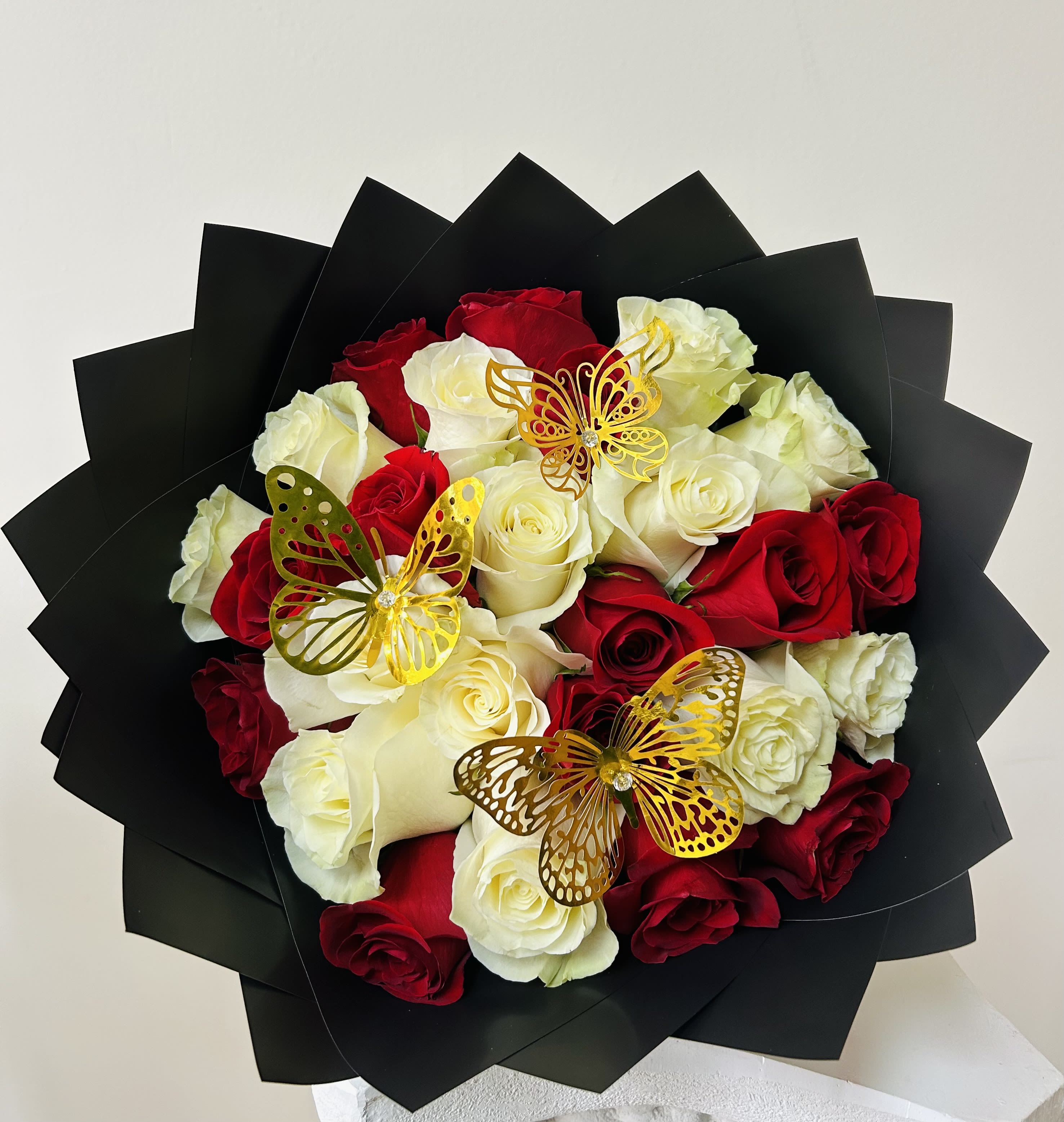 Bouquet of red and white roses with gold butterfly picks