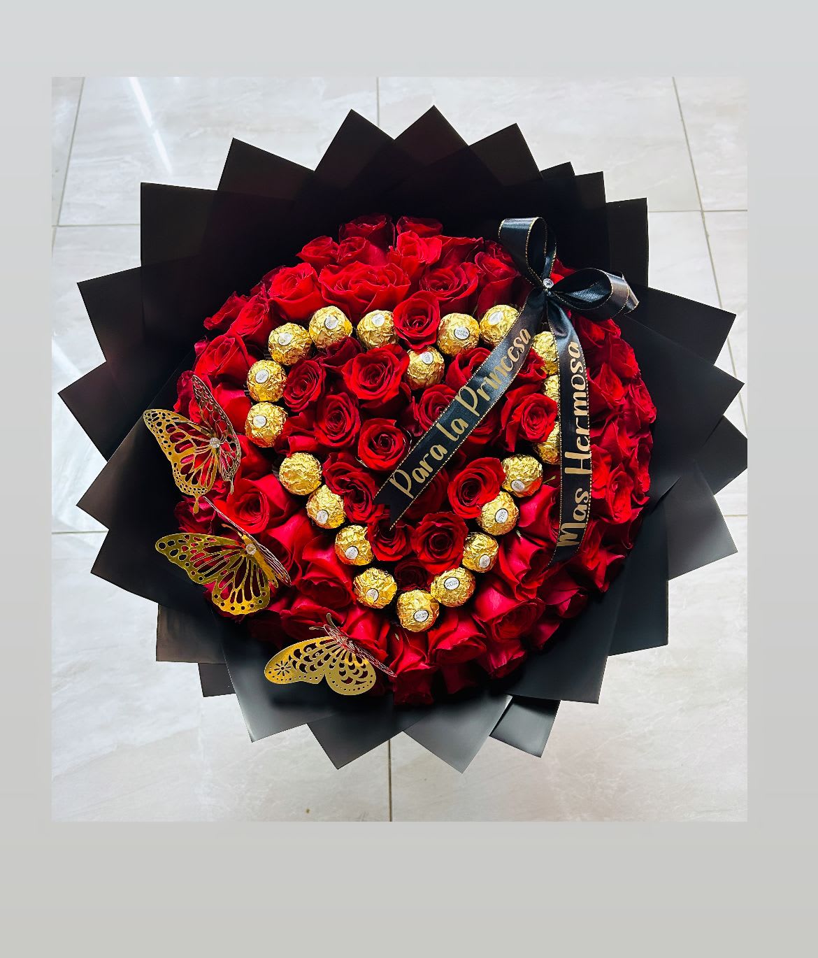 Heart-shaped bouquet of red roses with gold chocolates and black ribbon