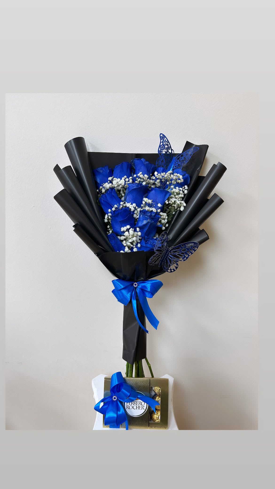 Blue rose bouquet with baby’s breath, black wrap, and a Ferrero Rocher box