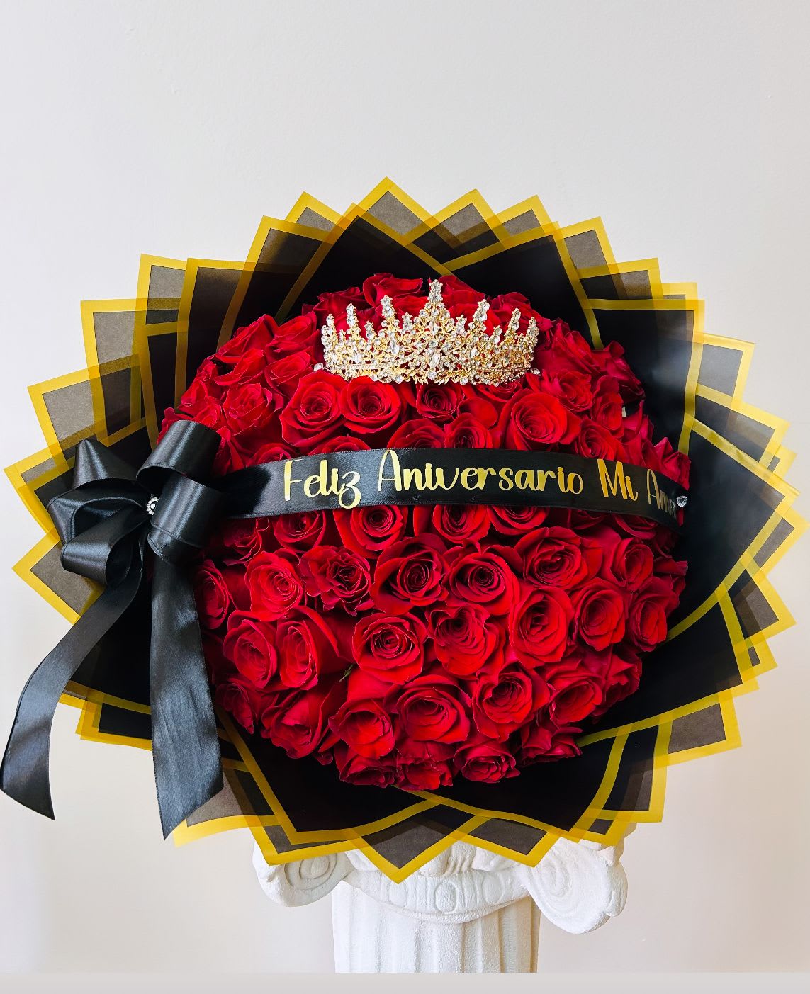 Large bouquet of red roses with a black ribbon and gold crown