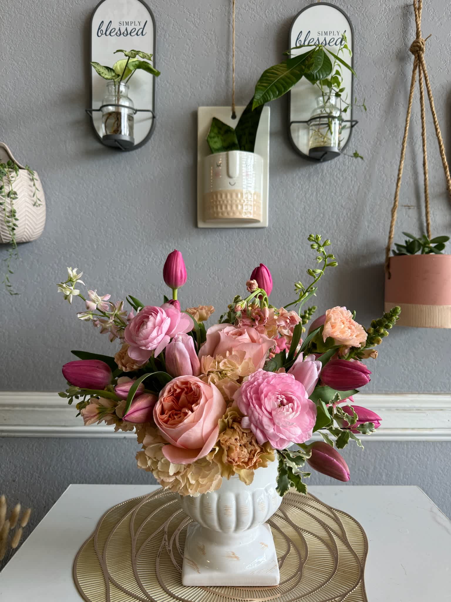 Pink and peach floral arrangement in a white vase