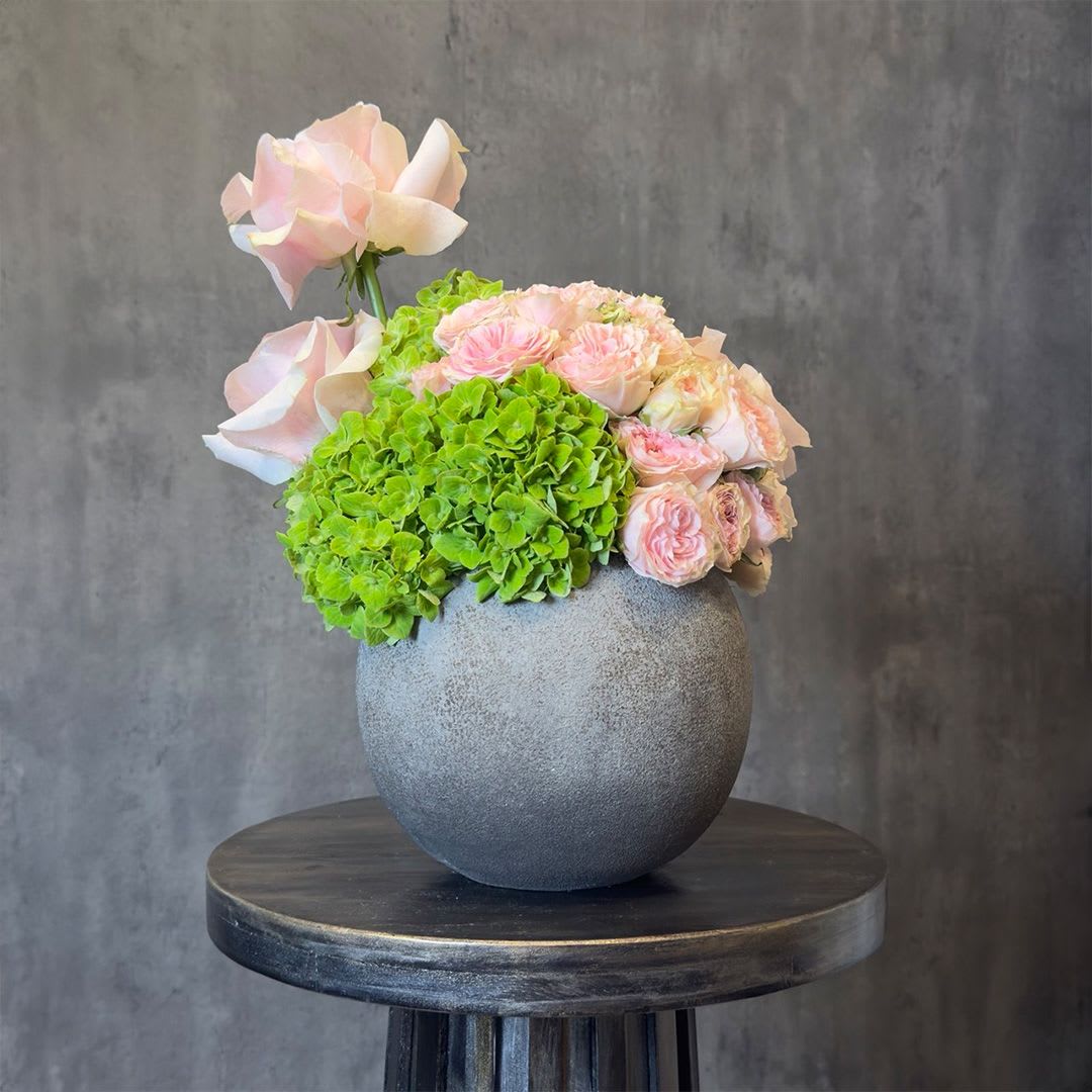 Blush Harmony - A soft and elegant arrangement of blush roses paired with fresh green hydrangea, designed in a modern ceramic vase. Delicate, airy, and refined, this piece brings a natural balance of softness and freshness to any space. Perfect for birthdays, anniversaries, or a graceful everyday gift. Custom greeting card included.