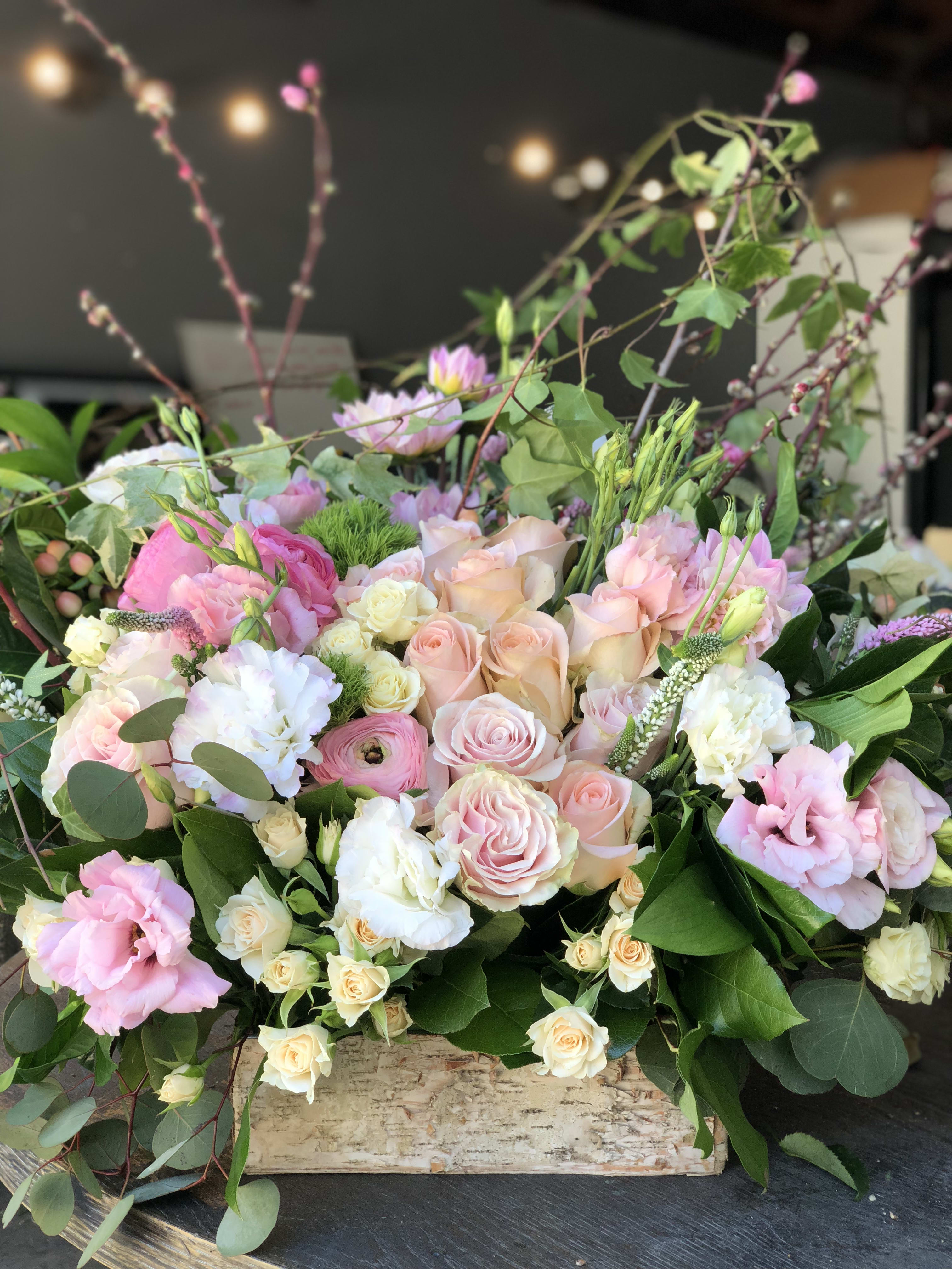 Pastel bouquet of roses and mixed blooms in a wooden box