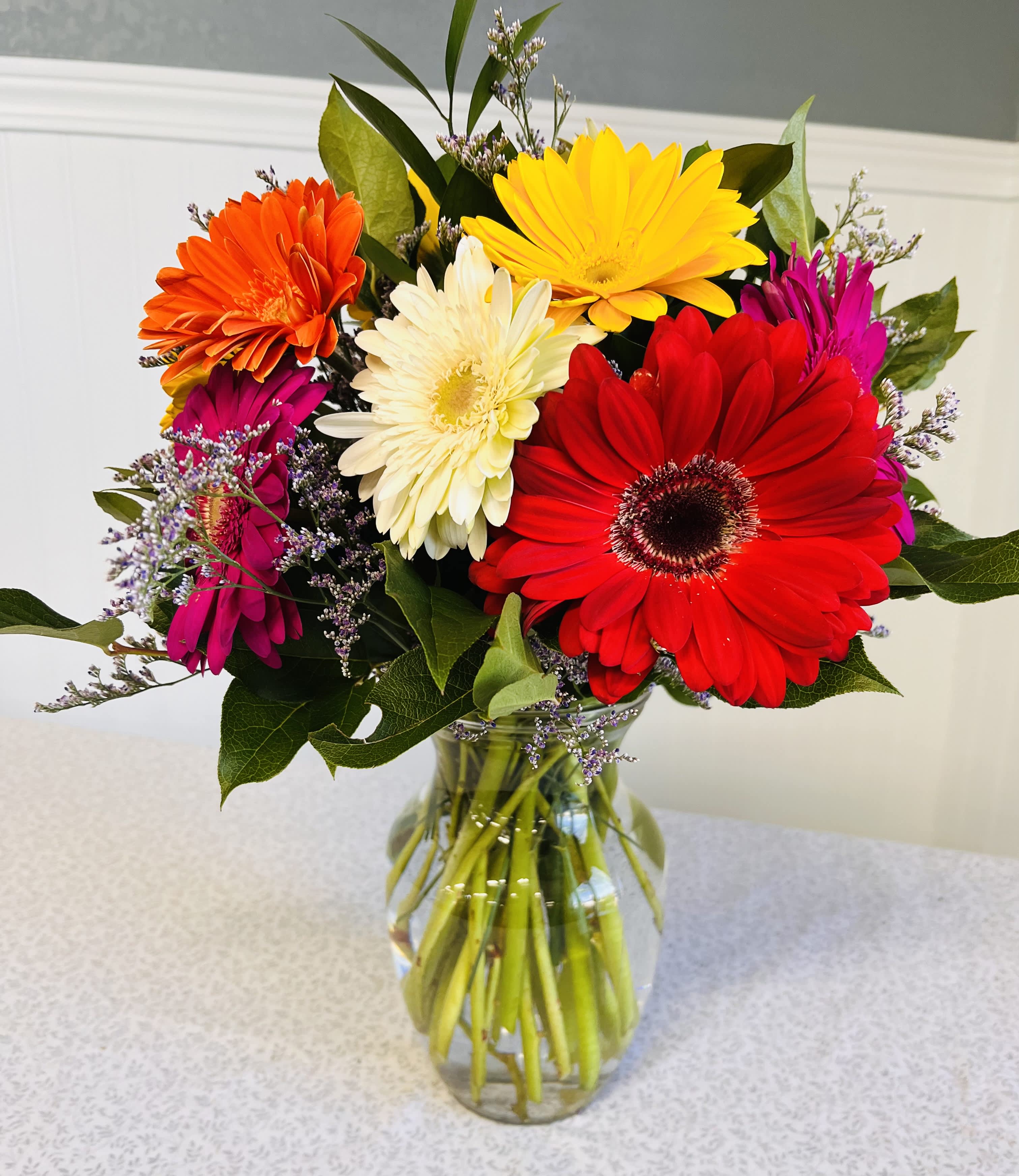 Colorful gerbera daisy bouquet in a clear glass vase