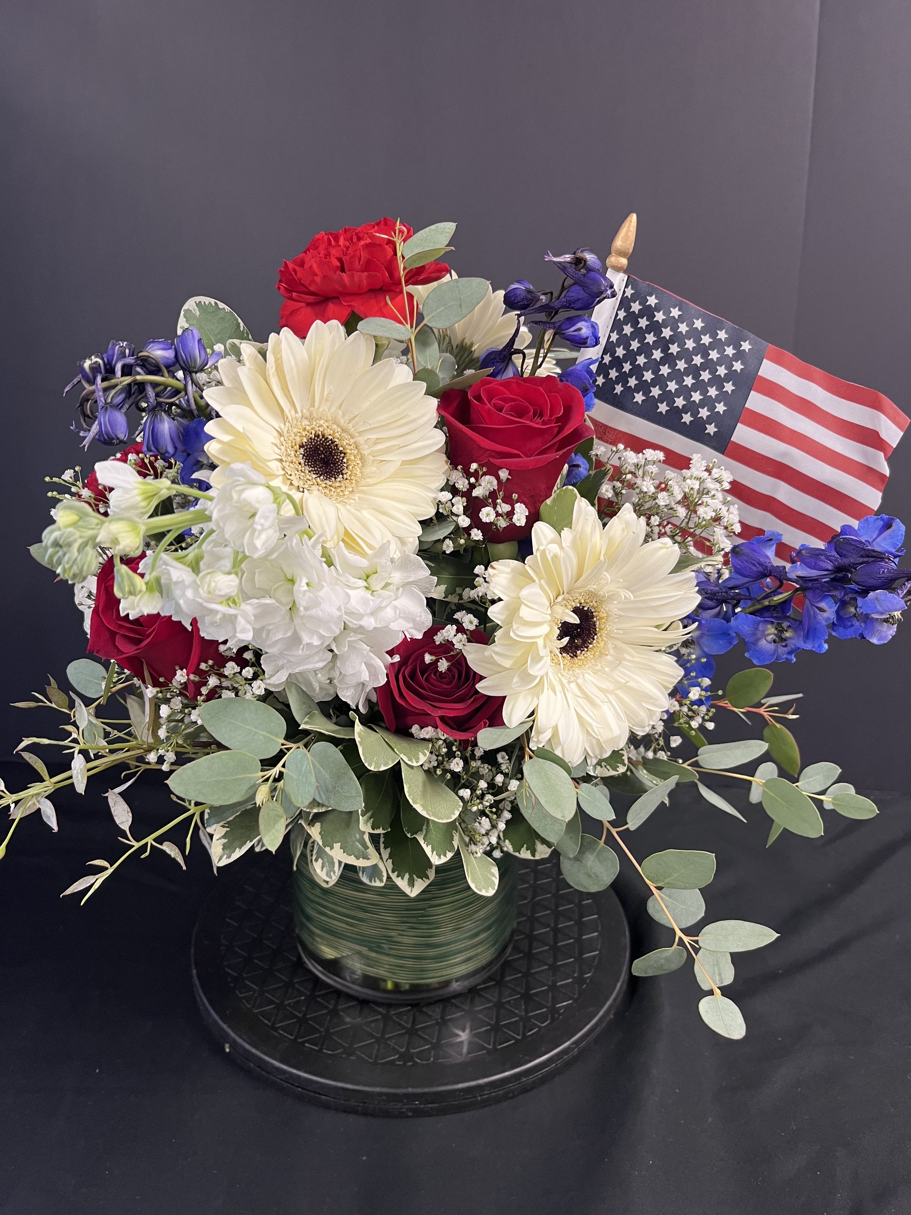 Patriot's Dream - Our Patriots bouquet is filled with beautiful Red, White and blue blossoms to celebrate our Patriots and Indepence day. American flag incuded. Premium is shown.