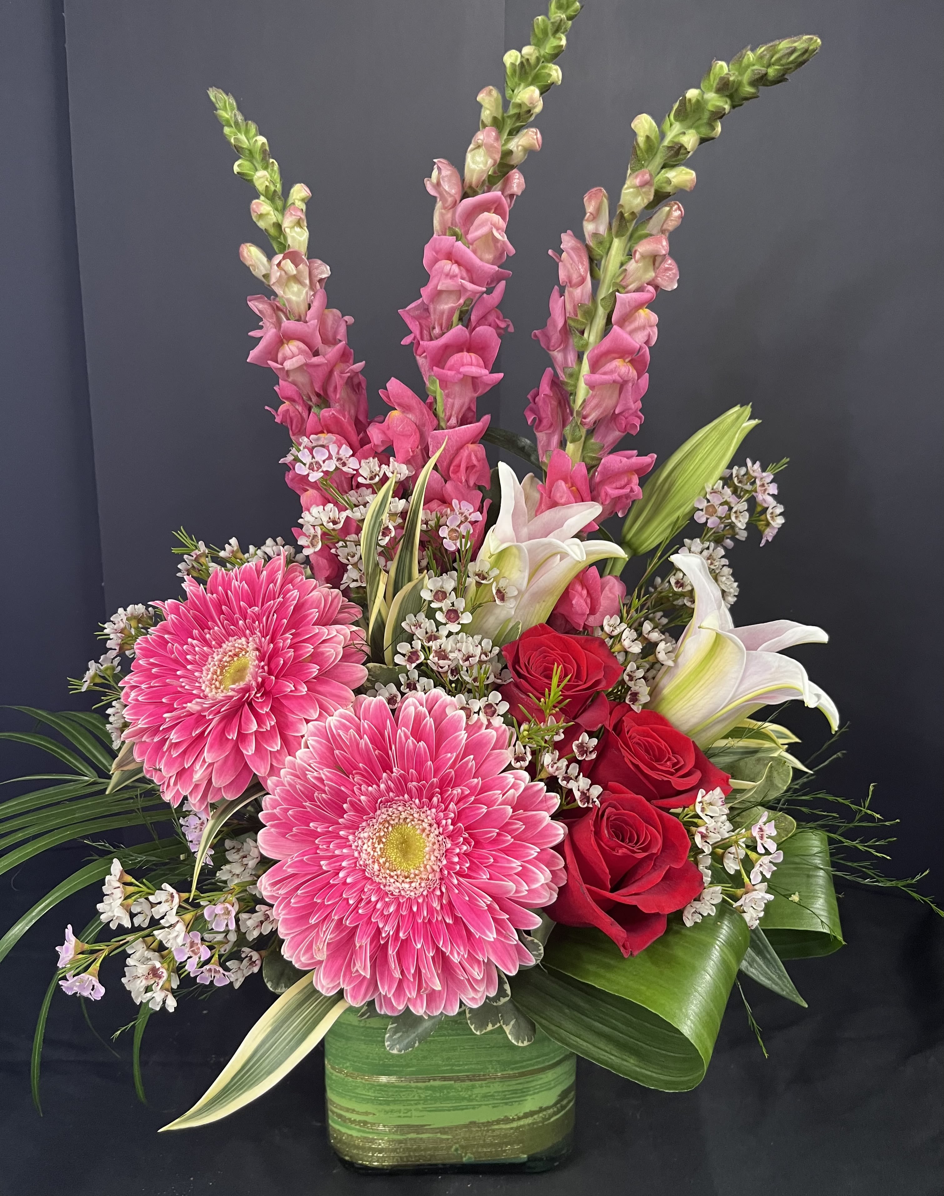 Felicity - Our beautiful Felicity bouquet conveys thoughts of happiness and joy. It comes in a glass cube with Ti leaf ribbon and one-sided.