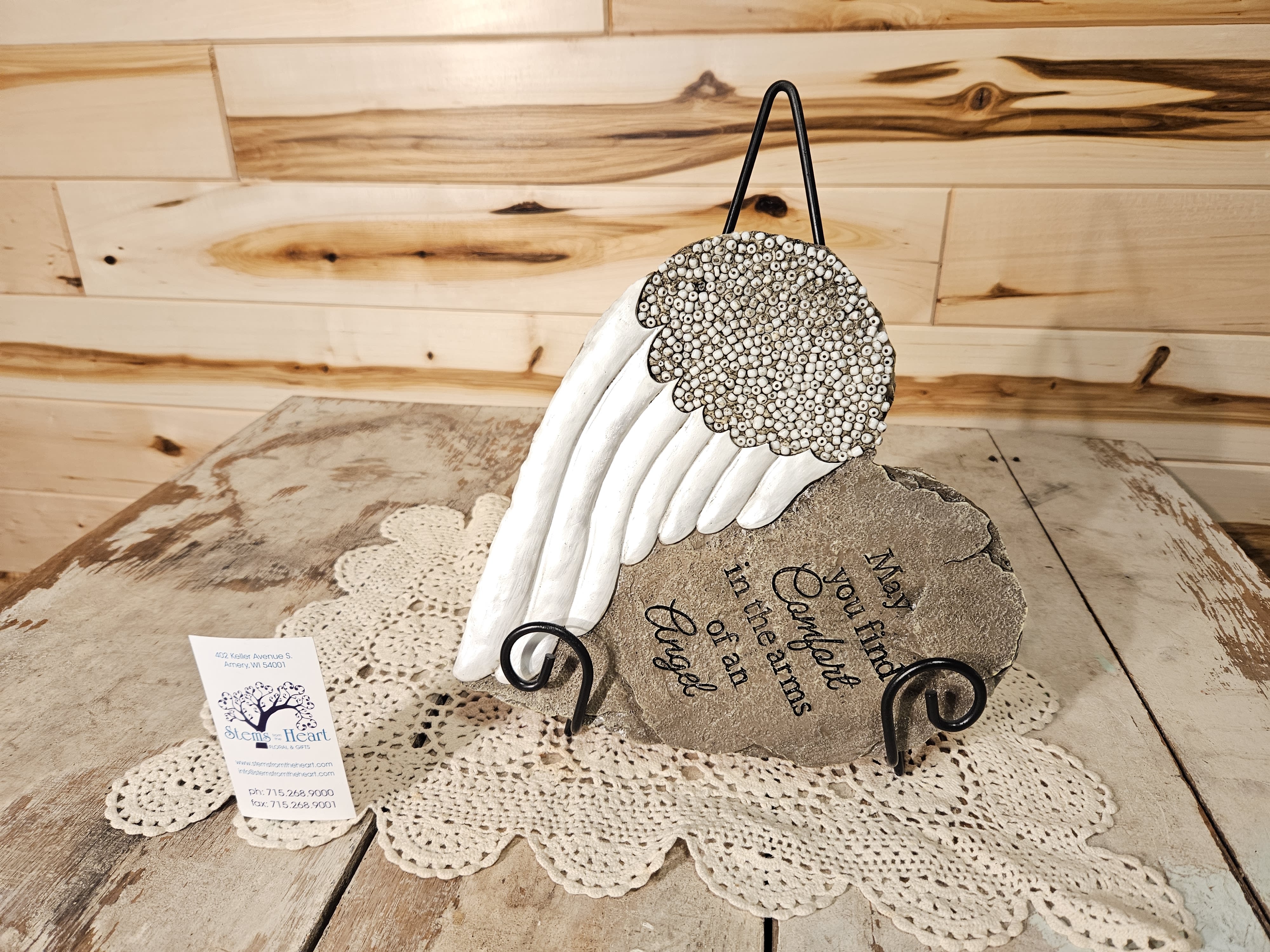 Decorative angel wing memorial plaque on a metal stand