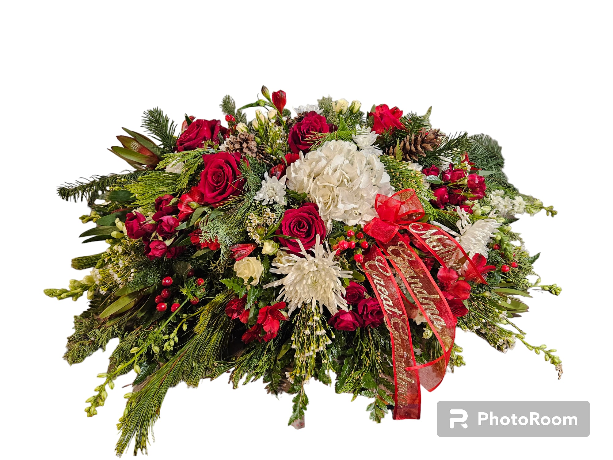 Large holiday floral arrangement with red and white flowers and a red ribbon