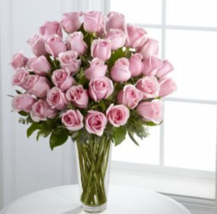 Pink roses arranged in a clear glass vase