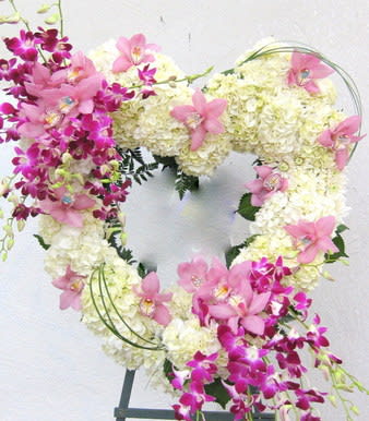 Heart-shaped floral wreath with pink orchids and white hydrangeas