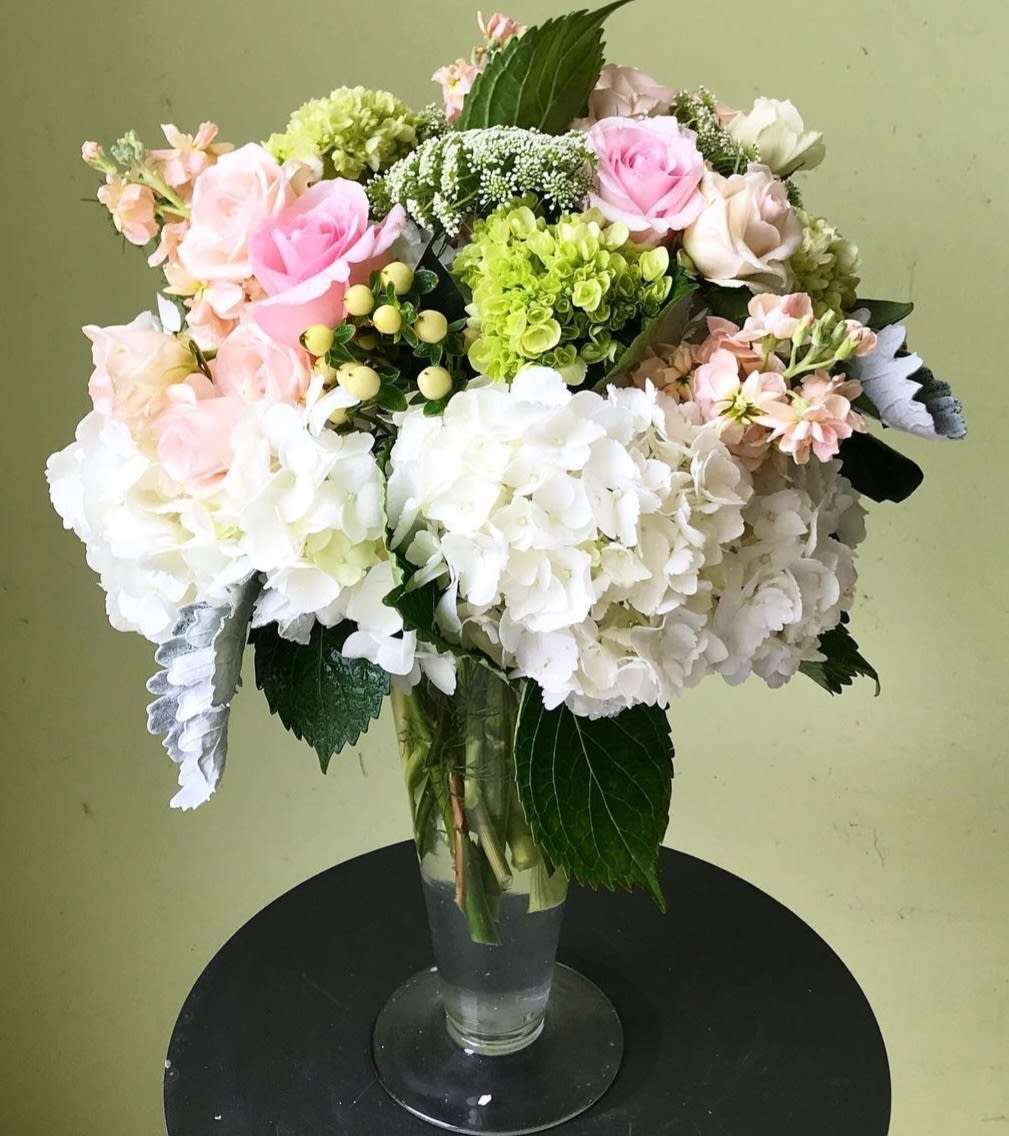 Bouquet of pink, white, and green flowers in a clear glass vase