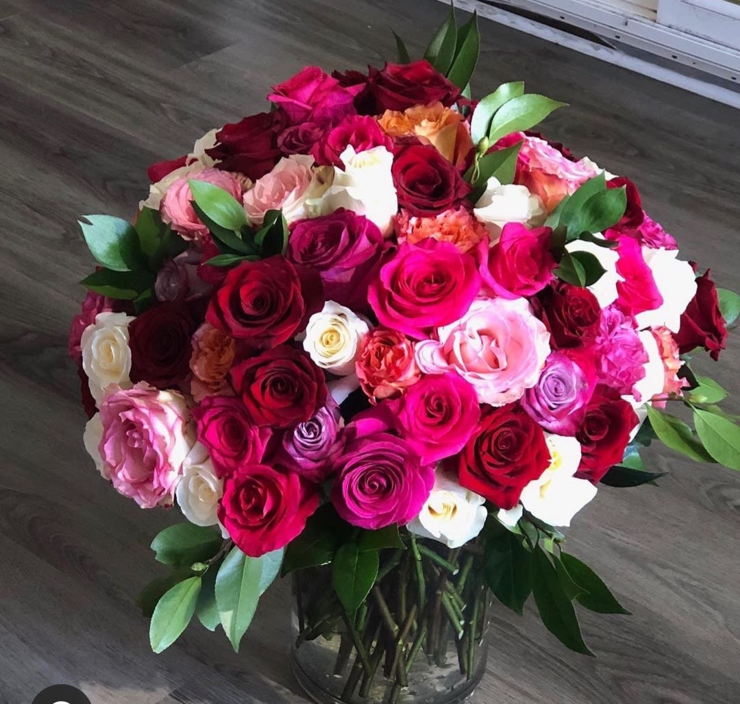 Large bouquet of multicolored roses in a glass vase