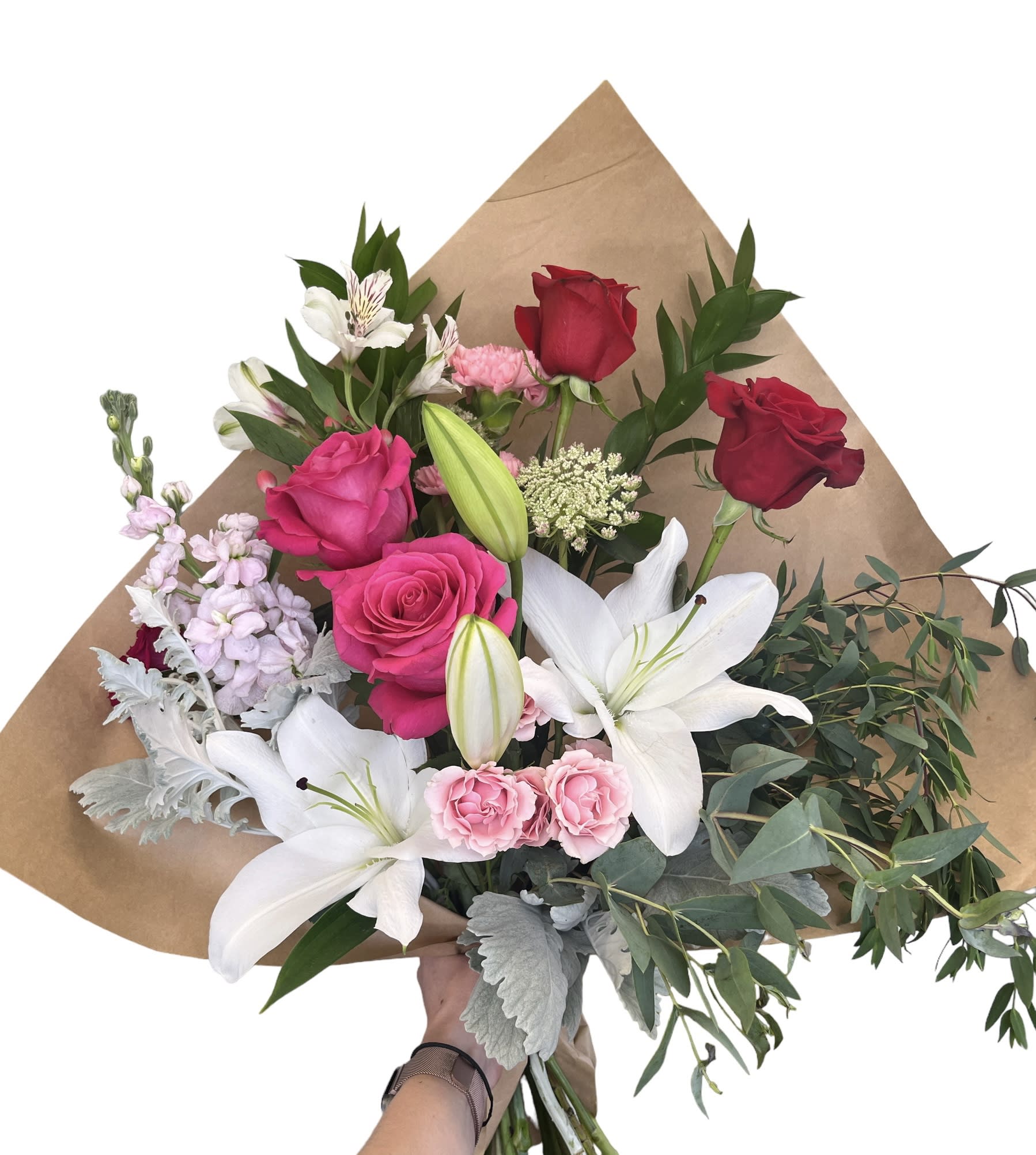 Bouquet of red and pink roses with white lilies and greenery in brown paper