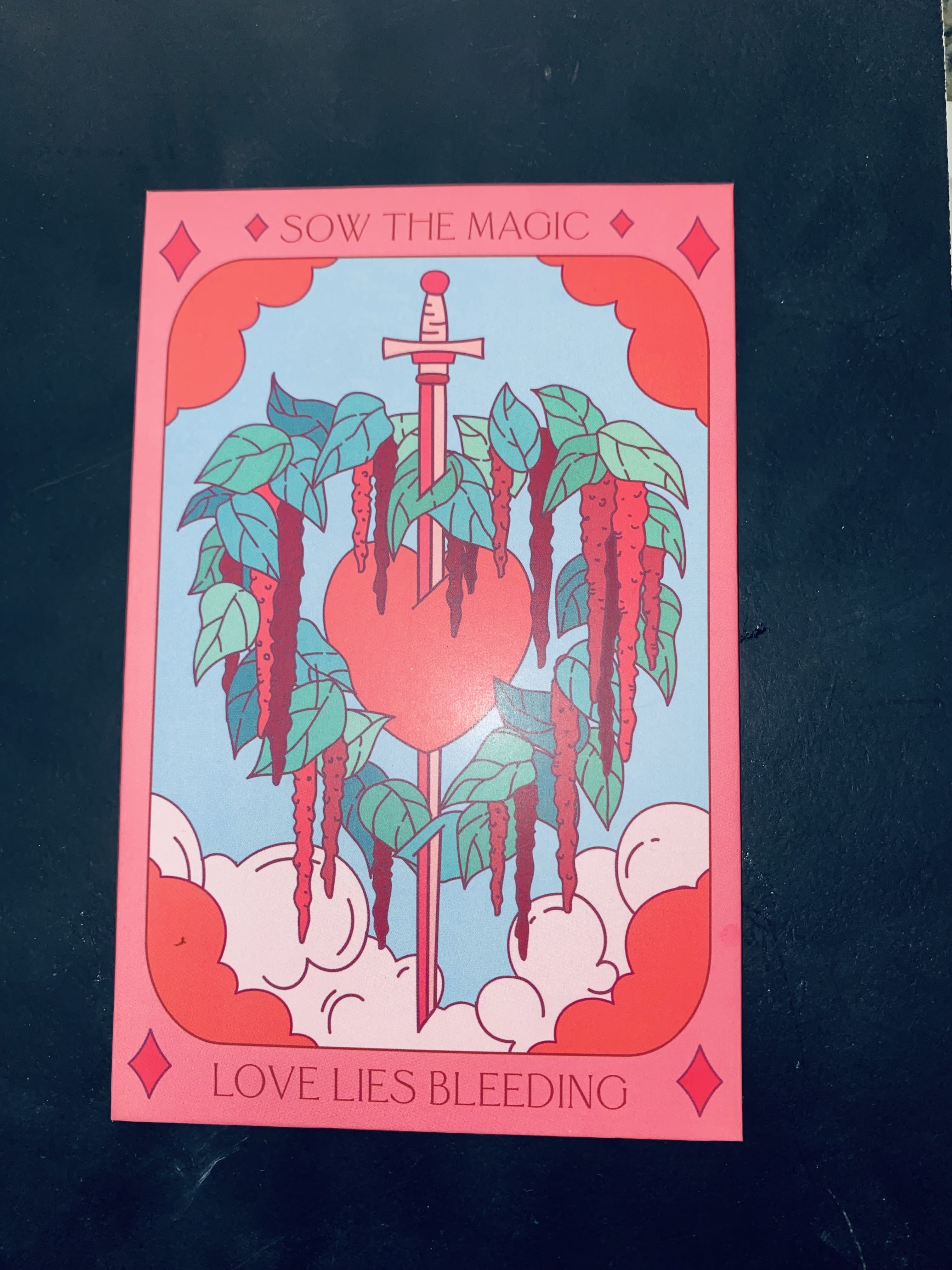 Illustrated card with a sword through a heart and hanging vines