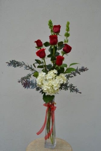 Tall bouquet of red roses and white hydrangea in a clear vase