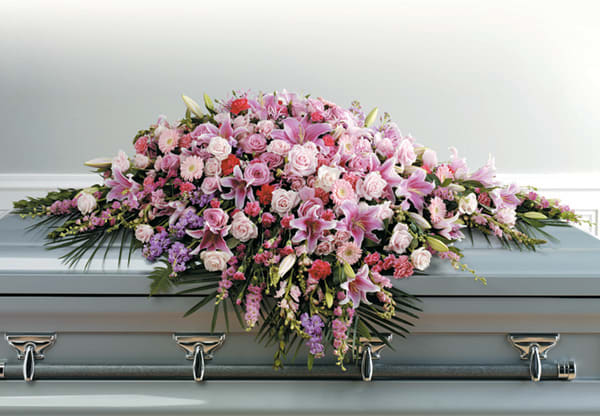 Pink and white floral casket spray with lilies and roses