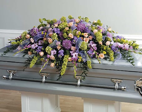Lavender and peach floral spray on a silver casket