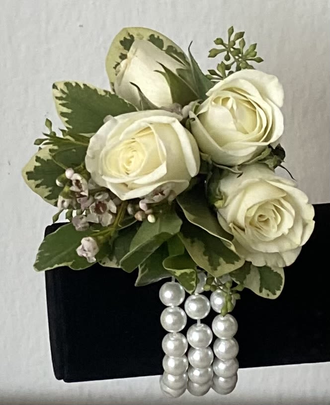 White rose corsage with pearl strands on a black wristlet