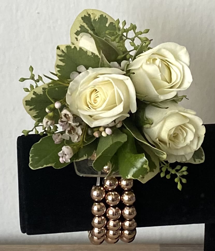 White rose bouquet with green foliage and a beaded handle