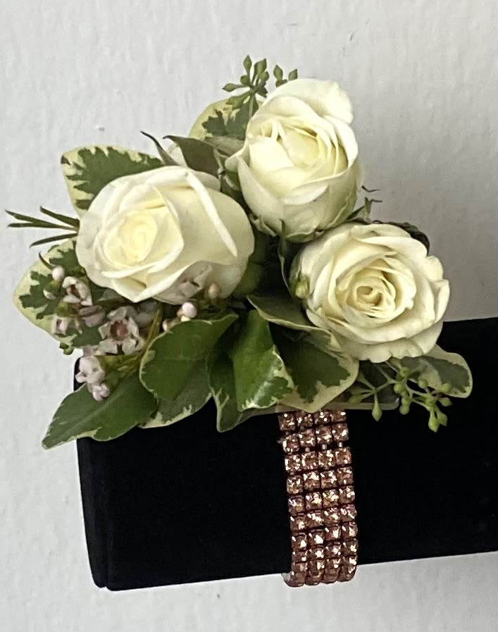 White rose bouquet with green foliage on a black box