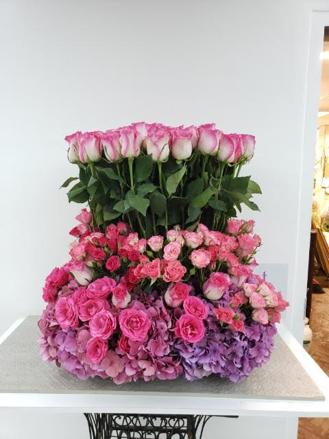 Large pink rose arrangement with hydrangeas on a table