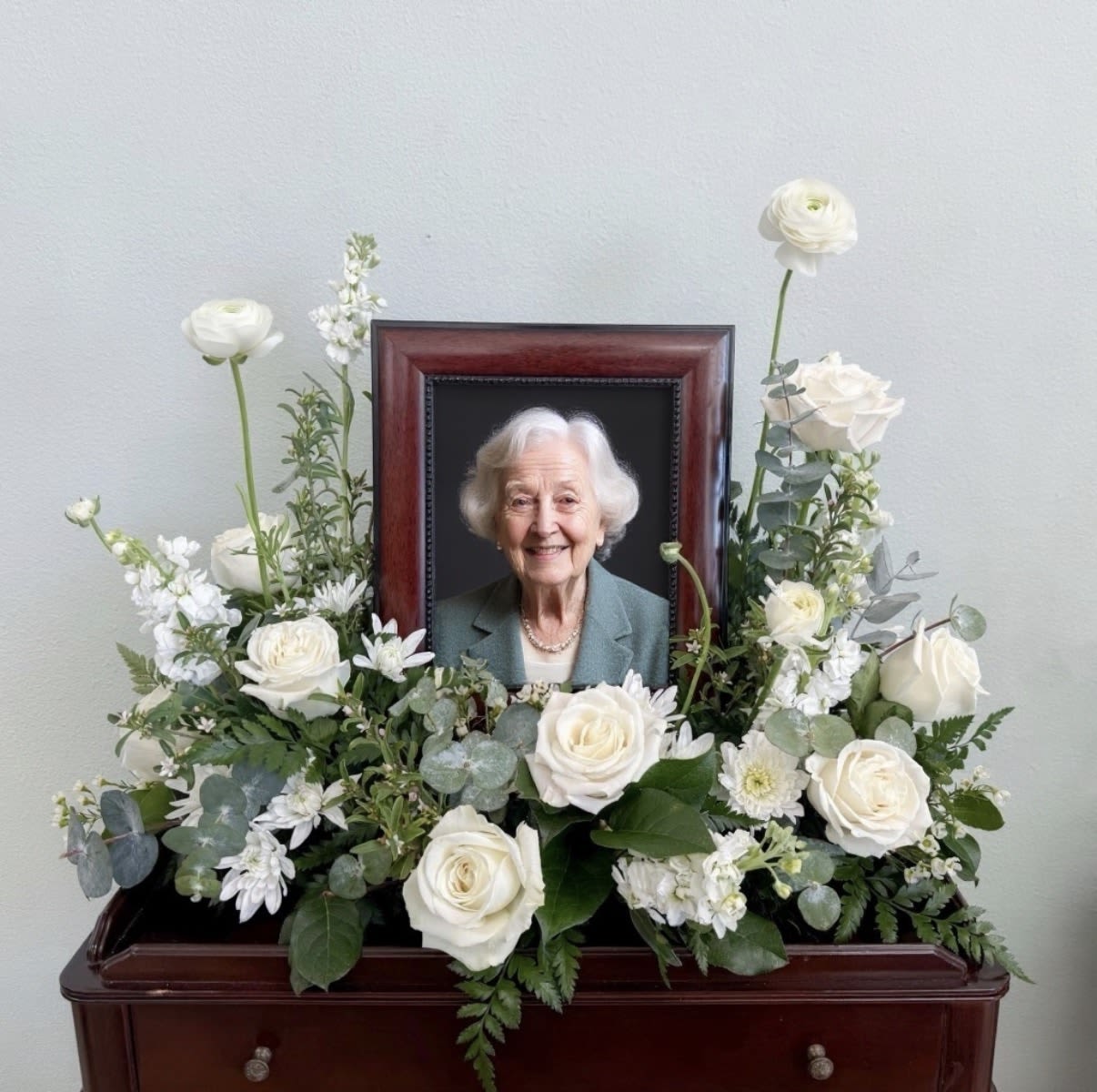 Eternal Photo Tribute - A graceful and meaningful design the Eternal Photo Tribute Arrangement is create to honor a cherished life with elegance. Designed to compliment a treasured photograph, it creates a heartfelt focal point for a memorial or celebration of life.          Frame not included. The image shown is the standard arrangement displaying a 12x14" frame. Please include the size of your frame in the notes or call to place your order. 