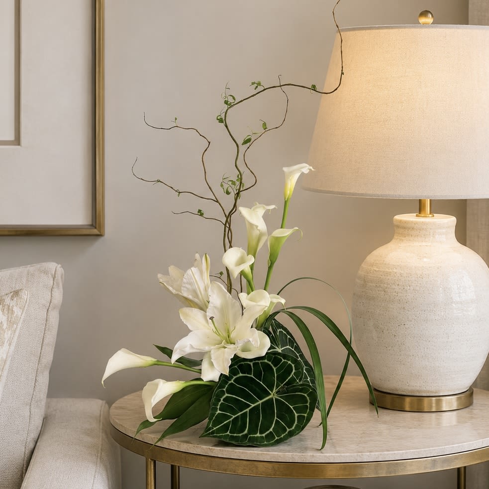 Lily Lover - Graceful, refined, and timeless, Lily Lover is designed for those who appreciate the quiet elegance of lilies. White oriental lilies and graceful calla lilies create a striking focal point, complemented by sculptural anthurium foliage and naturally twisting willow for a design that feels both modern and artistic.            Its serene palette and clean lines make it a beautiful expression of sympathy and remembrance, while its sophisticated style is equally at home as a thoughtful gift for anyone who simply loves lilies. Whether sent to honor a cherished life or to brighten a peaceful home, Lily Lover offers beauty with a sense of calm, grace, and lasting elegance.