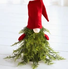 Red velvet gnome figure with a long green mossy skirt