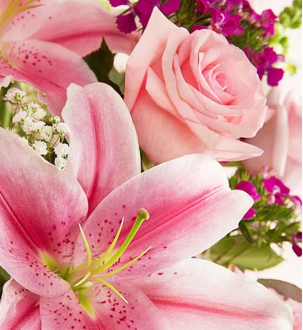 Pink lilies and a pale pink rose with purple filler flowers