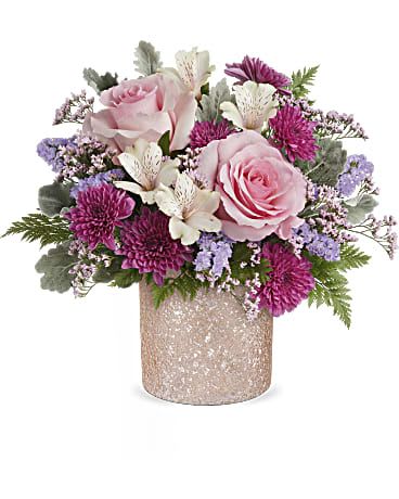 Pink roses and purple blooms arranged in a glittery vase