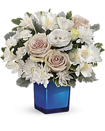White and blush bouquet in a blue glass vase