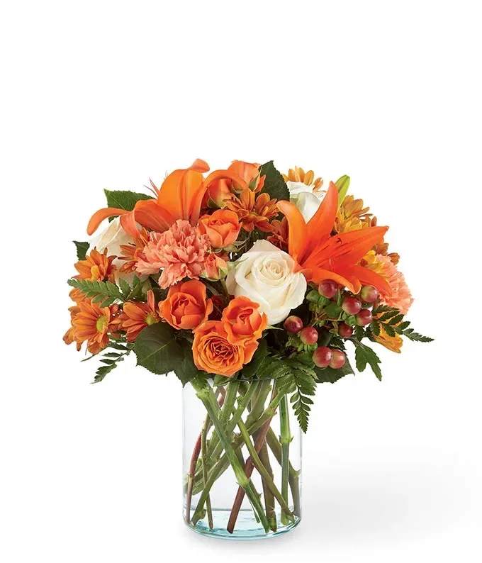 Orange and white flower bouquet in a clear glass vase