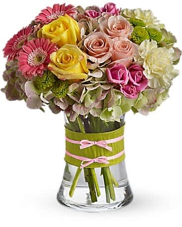 Mixed bouquet of roses, gerbera daisies, and hydrangeas in a glass vase