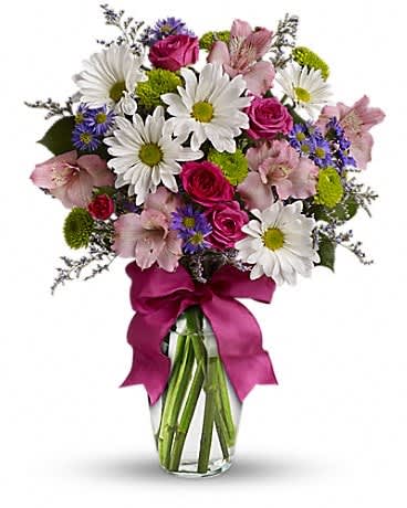 Bouquet of pink roses, white daisies, and purple flowers in a glass vase